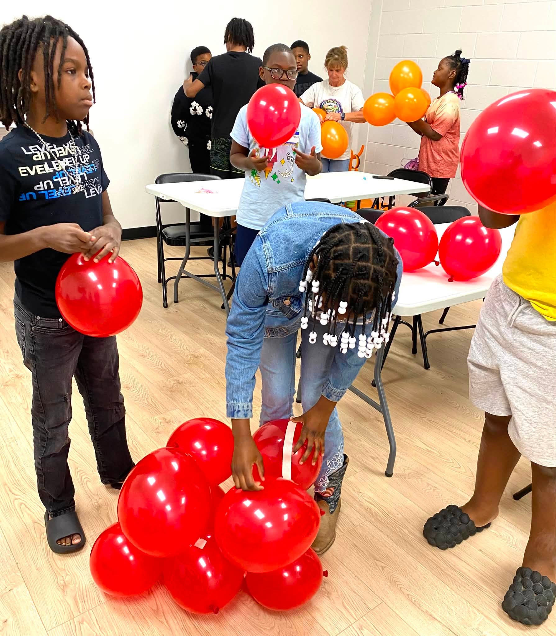 Some kids with red balloons.